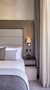 A tour of a boutique hotel room in London, highlighting the room's features, technology, bathroom, and balcony, ending with a tea service.