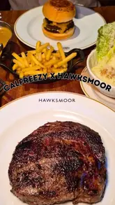 A review video featuring a creator trying the limited-edition Calfreezy x Hawksmoor burger. The video includes close-up shots of the burger, steak, salad, and chips, along with the creator's reaction and commentary on the quality of the ingredients.