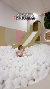A short, edited montage showcasing the facilities of a new soft play cafe in Nottingham, featuring a toddler exploring the climbing equipment, slides, and ball pit.