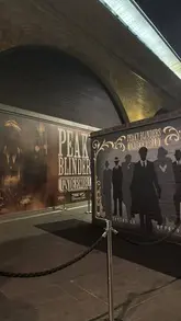 A promotional video showcasing the Peaky Blinders Underworld immersive experience in London, highlighting the set design, themed decor, and interactive elements like the horse racing game.