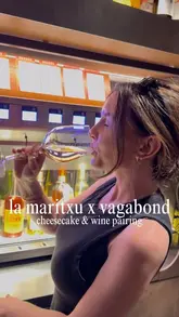 A creator visits Vagabond Wines in Carnaby to showcase a limited-time collaboration with La Maritxu, featuring Basque cheesecake pairings with their self-serve wine selection. The video highlights the interactive experience of choosing wines and enjoying the cheesecake, charcuterie, and cheese boards in a social setting.