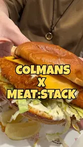 A creator reviews a collaboration menu between Colmans and Meat:Stack, featuring a hot fish sandwich, curry chips, and a dandelion iced tea. The video includes close-ups of the food and the creator's reaction.