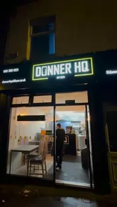 A video review of a late-night takeaway spot in Oldham called Donner HQ. The creator visits the venue, shows the menu, and reviews a 'munchbox' containing burgers, donner meat, and fries, as well as a house special donner on naan.