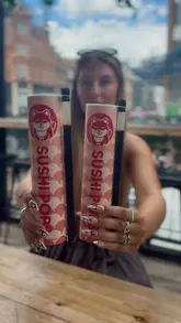 A short, energetic video showcasing a visit to Sushi Pops at Boxpark Shoreditch, highlighting the unique tube-based sushi concept, the ordering process via kiosk, and the final product.