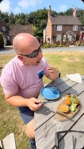A couple visits The Tiger Inn, enjoying a meal outdoors in the pub garden. The video features close-ups of various dishes, including mussels, scallops, and fish cakes, alongside drinks, and provides a tour of the exterior of the venue.