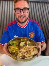 A creator presents a breakfast platter at a new cafe in Oldham, highlighting a fusion of Asian and English breakfast styles.