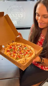 A review of The Real Pizza Company in Wigston, showcasing their pizza menu, including butter paneer and margherita options, as well as sides like cheesy dough balls and halloumi bites.