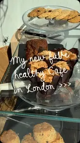 A short, handheld vlog-style video showcasing a visit to The Good Life Eatery, highlighting their healthy food options, specifically gluten-free muffins and banana bread, alongside matcha and smoothies.