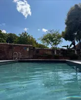 A bright, inviting photograph of a swimming pool at Hotel du Vin, Exeter, used to promote their 'dip & dine' spa and lunch package. The image focuses on the pool setting under a clear blue sky.