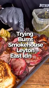 A group of friends visits Burnt Smokehouse in Leyton, East London, showcasing a large platter of smoked meats, sides, and desserts. The video features close-ups of the food preparation, the menu, and the group's enthusiastic reactions to the meal.