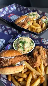 A creator reviews a 'Munchy Box' from Chicken George Jnr, highlighting its availability for delivery via the GoGetters app in St Albans.