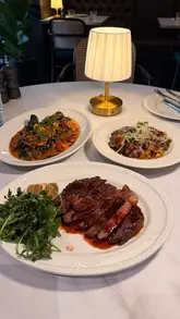 A review of a new Italian restaurant in Notting Hill, featuring a fourth-generation Roman chef. The video showcases the interior, the cooking process, and several dishes including burrata, truffle croquettes, squid-ink cappellini, wagyu beef cheek pappardelle, wagyu rib-eye, and tiramisu.