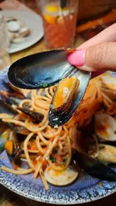 A montage video showcasing various Sicilian dishes at Sicilian NQ in Manchester, featuring close-ups of pizza, pasta, seafood, and desserts, along with shots of customers enjoying the food.