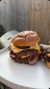 A creator reviews a new 3-in-1 BBQ grill by cooking smash burgers in their garden, providing a conversational walkthrough of the cooking process.