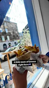 A review of a Greek street food venue, showcasing various dishes like halloumi fries, gyros, and souvlaki wraps, along with the interior and menu.