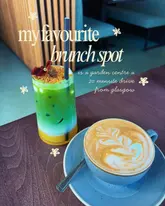 A well-composed, bright, and inviting shot of a matcha drink and a flat white coffee, presented on a wooden table in a cafe setting. The image uses clear text overlay to highlight the venue as a brunch spot.