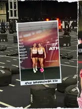 A photo of two women posing in a gym setting, framed as a Polaroid, documenting their participation in a fitness competition.