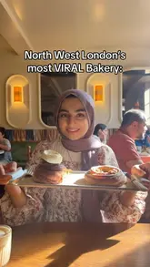 A short vlog-style review of a bakery in Queens Park, London, highlighting the variety of fresh pastries, the aesthetic interior, and the outdoor seating area.