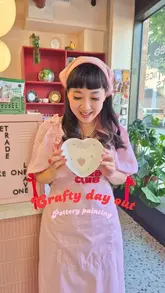 A 'come with me' style vlog showcasing a visit to a pottery painting cafe called Carb Club Ceramics, highlighting the cute pink decor, the trinket trade box, and the creative activity.