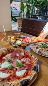 A couple visits a pizza restaurant to try their new lunch deal, showcasing the food, drinks, and interior.