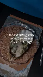 A couple reviews an immersive tasting menu experience called 'Source: Sea to Land' held inside a 360-degree cinema dome in Cardiff, featuring food by Hiraeth Kitchen.