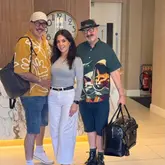 A promotional image featuring three guests checking into the Queen's Hotel Belfast, intended to showcase the venue's hospitality and welcome atmosphere.