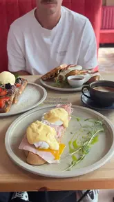 A short montage showcasing the brunch menu and interior of Mirella in Leytonstone, featuring dishes like eggs benedict, waffles, and coffee, while highlighting the dog-friendly atmosphere.