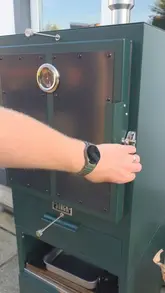 A home cooking video demonstrating the use of a charcoal smoker to prepare nachos. The creator lights the charcoal, assembles the nachos in trays with toppings, and smokes them until the cheese is melted.