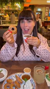 A couple visits Broadway, a restaurant and late bar in Clondalkin, to review their dinner menu. The video features shots of the venue's interior, the menu, and close-ups of various dishes including arancini, prawns, steak, lasagna, and hot donuts, interspersed with the creators' reactions.