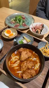 A short review-style reel showcasing a visit to UMI, a Japanese restaurant in Edinburgh. The video features close-ups of various dishes including gyoza, takoyaki, tuna tataki, curry udon, and tonkatsu, alongside shots of the restaurant's interior and the creator enjoying the meal.