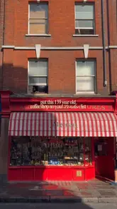 A short, handheld vlog showcasing the historic Algerian Coffee Stores in Soho, London, highlighting its long-standing presence, coffee and tea selection, and cozy, traditional atmosphere.