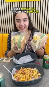 A creator reviews Brazilian burgers at Cozinha do Humberto in London, showcasing various burger options, fries, snacks, and a drink.