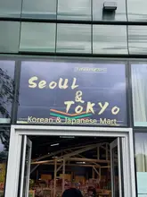A casual, eye-level storefront shot of 'Seoul & Tokyo', a Korean and Japanese mart that also serves food. The image is a functional, amateur-style capture that clearly identifies the venue but lacks professional lighting or composition techniques.