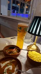 A creator visits the new Indi's restaurant in Bournemouth, showcasing the menu, atmosphere, and various dishes including poppadoms, pani puri, prawns, and dosa.