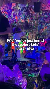 A high-energy reel showcasing a fluid art party experience for children at a studio, highlighting the creative activity, the protective gear provided, and the freedom for kids to paint the walls.