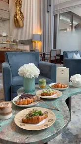 A high-quality, aesthetic montage showcasing a selection of gourmet croissants and a layered matcha drink at La Croissanterie within the Four Seasons Hotel London at Park Lane. The video features slow, deliberate camera movements focusing on the textures and presentation of the food, set against the backdrop of an elegant, upscale lounge.