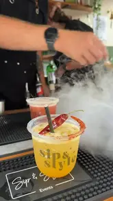 A short montage video showcasing a food festival in Lichfield, featuring cocktails with dry ice effects, jerk chicken, and outdoor seating.