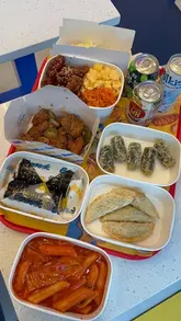 A montage of various Korean street food dishes including corn dogs, fried chicken, kimbap, and tteokbokki at a Bunsik restaurant.