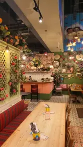 A promotional video for Comptoir Libanais in Spinningfields, Manchester, featuring shots of the restaurant's vibrant interior decor and a variety of Lebanese dishes including hummus, skewers, and salads.