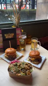The video features a creator visiting The Northern Market in Leeds to try burgers and loaded fries from Big Buns. It includes close-up shots of the food, the creator eating, and a brief pan of the venue's interior.