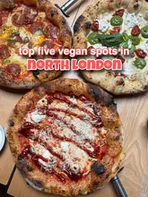 A bright, overhead shot of three distinct pizzas arranged on a wooden table, serving as a clear and inviting cover image for a listicle about vegan dining in North London. The composition is balanced, and the lighting effectively highlights the textures of the toppings and crusts.