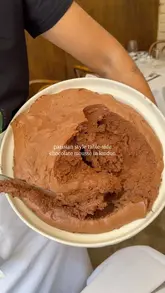 A short, focused video showcasing a tableside chocolate mousse service at a French-style restaurant in London. The clip highlights the texture of the mousse being scooped onto a plate, followed by a brief shot of the dessert being enjoyed.