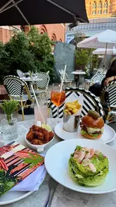 The video provides a tour of the Laurent-Perrier champagne terrace located at the St Pancras Renaissance Hotel in London. It highlights the outdoor seating area, the architecture of the hotel, and the available food and drink options, including champagne cocktails and light bites.