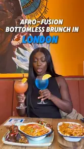 A creator-led vlog showcasing an Afro-fusion bottomless brunch experience at The Merge in Brixton. The video features the creators enjoying cocktails, starters, and a large sharing platter, while highlighting the venue's atmosphere, including a live DJ.