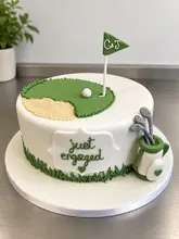 A high-quality, well-lit photograph of a custom-made, golf-themed engagement cake. The cake features a fondant putting green, a sand bunker, a golf bag with clubs, and the text 'Just Engaged' with the couple's initials on the flag.