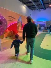 A candid shot of a father and child walking through the MiniBrum exhibit at Thinktank Science Museum in Birmingham, showcasing the interactive and child-friendly environment of the venue.