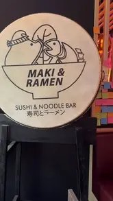 A short, energetic video showcasing a visit to Maki & Ramen in Leicester, featuring shots of cocktails, sushi, gyoza, and ramen, alongside the venue's vibrant interior decor.