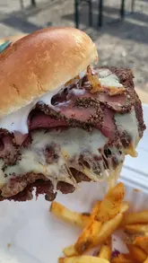 A montage showcasing various street food vendors at a local event held at Shifnal Cricket Club, featuring burgers, loaded fries, curry, pizza, and crumble.