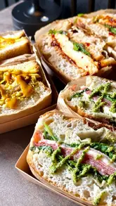A montage of various sandwiches and hot drinks at Craft & Crumb, featuring close-ups of the food and a brief look at the cafe interior.