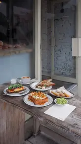 A montage of brunch dishes and coffee at a cafe, featuring French toast, eggs, and pastries.